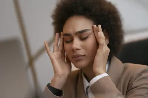 Mulher com mãos na cabeça representando fadiga mental e cansaço por excesso de decisões