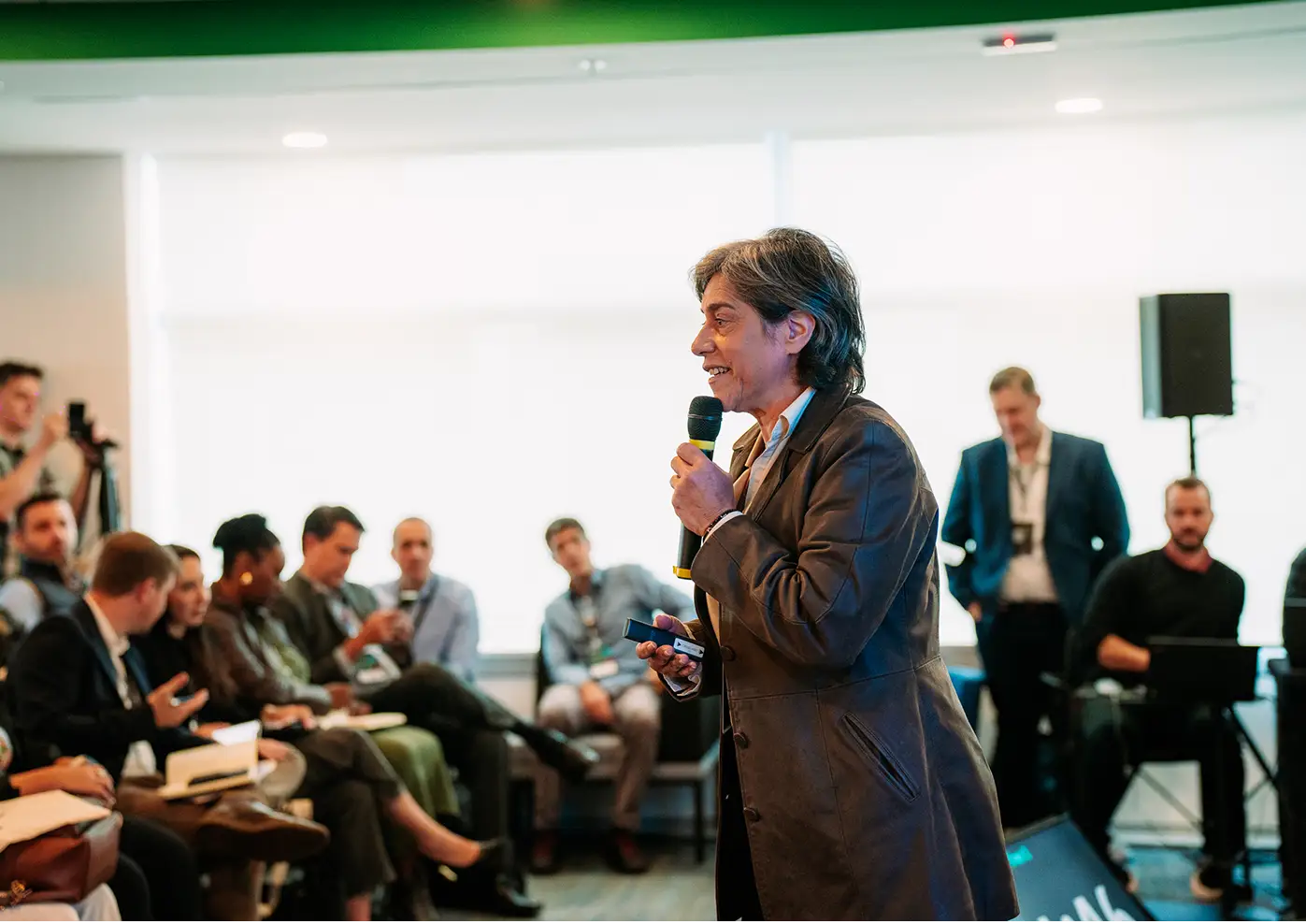 Carla Tieppo palestrando para público em evento corporativo