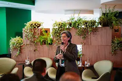 Carla Tieppo durante palestra no GenAI Summit 2025 sobre inteligência artificial e tomada de decisão